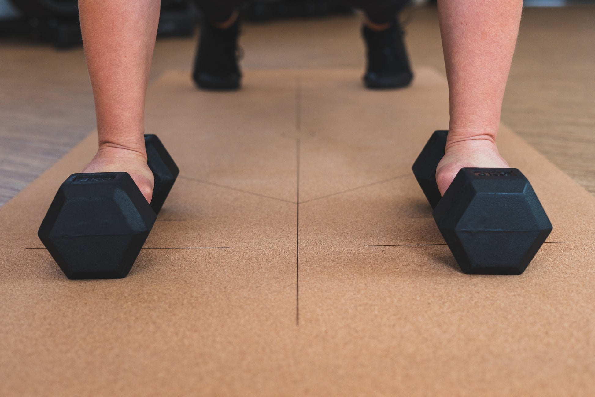 ROOTD Elite Align Design. Non-toxic eco cork exercise mat with alignment lines in a gym setting with dumbells. 